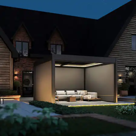 Dark grey pergola with LED roof lighting and fully retracted blinds, creating a cosy seating area on a garden patio at dusk.