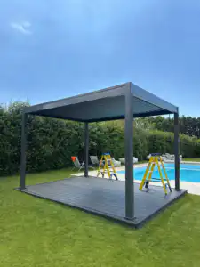 Premium aluminium pergola installed on a wooden deck by a swimming pool, providing shade and elegance.