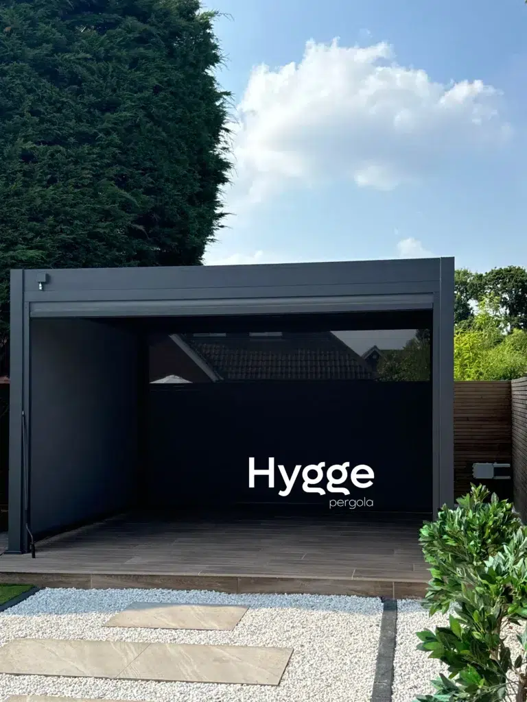 Dark grey aluminium pergola with privacy side panels, creating a sheltered outdoor retreat.