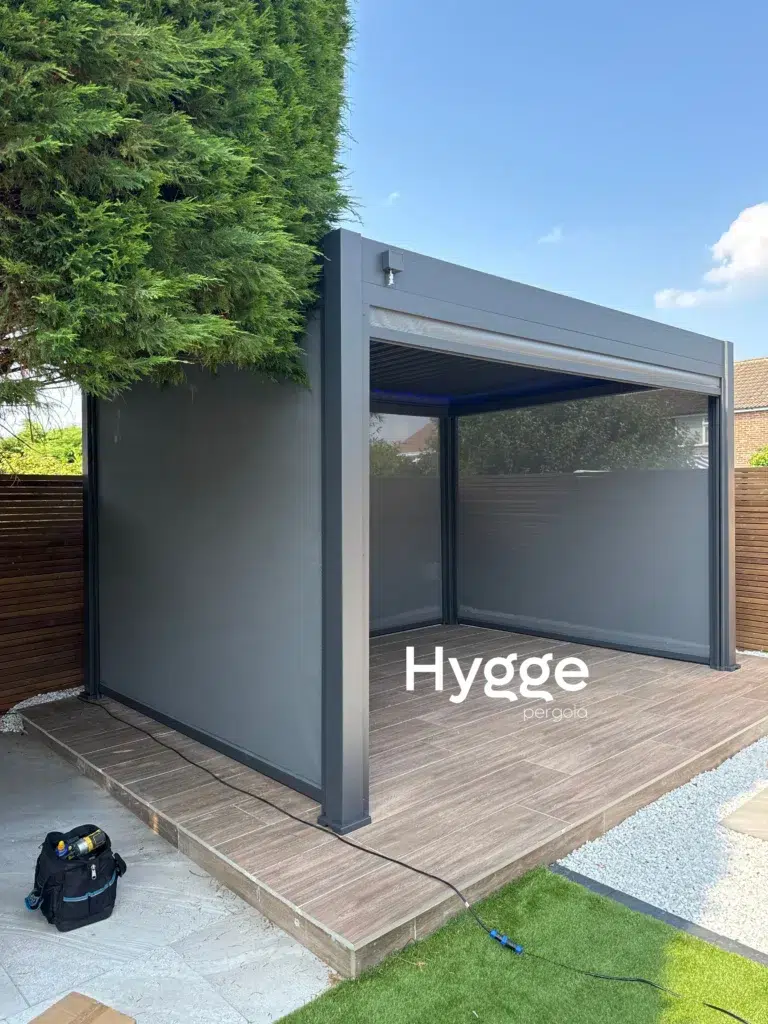 Modern dark grey aluminium pergola with privacy screens, ideal for contemporary outdoor designs.