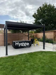 Spacious freestanding dark grey aluminium pergola with adjustable louvres, offering shade control.